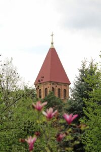 Jézus Szíve Római Katolikus Templom tornya virágzó fákkal körbevéve